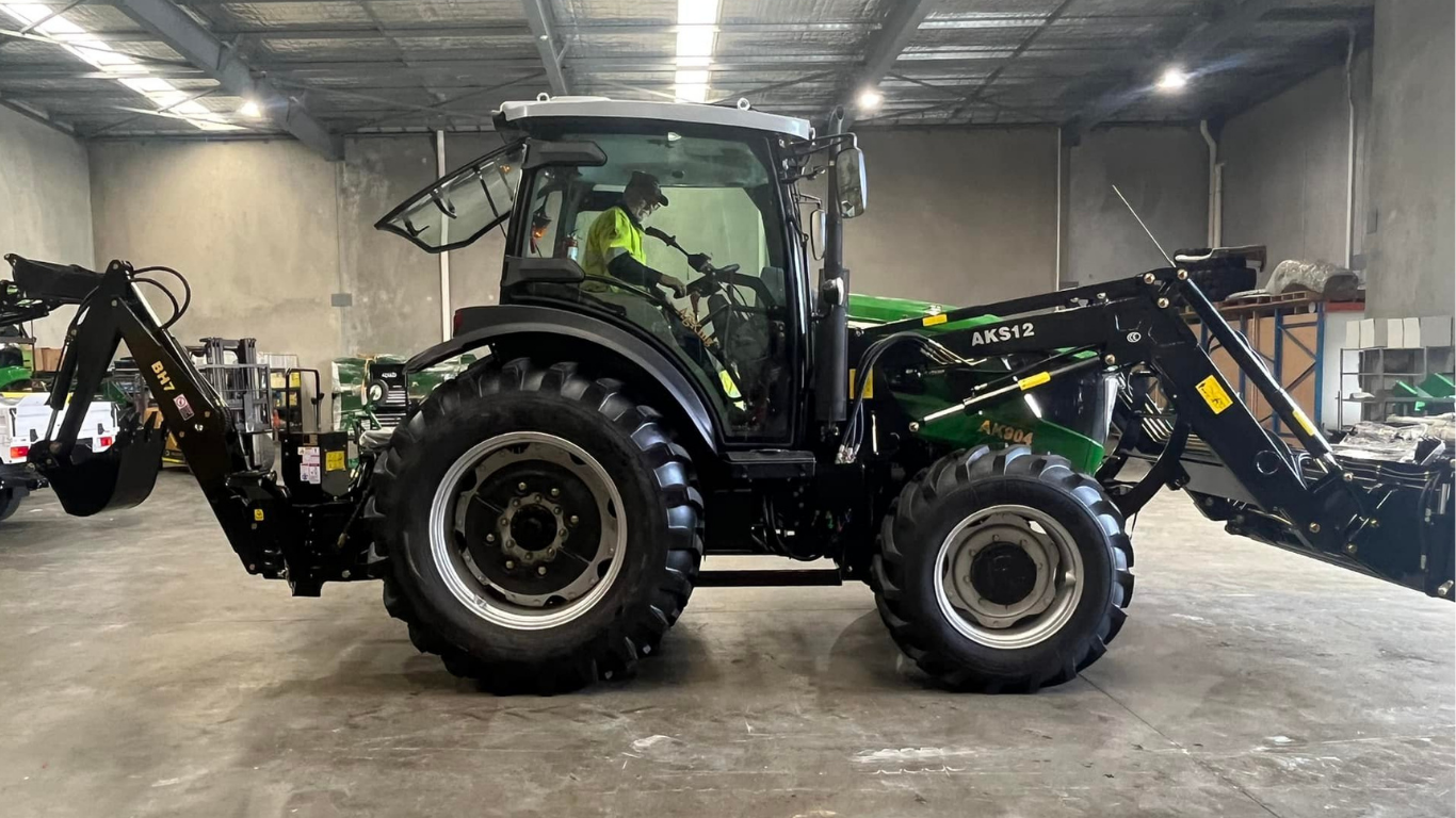 AgKing AK904 with backhoe implement parked in a grey shed
