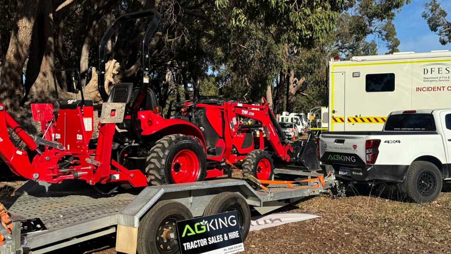 Red TYM compact tractor with front loader and backhoe attachment loaded on a trailer, branded AgKing Tractor Sales & Hire